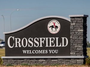 Welcome sign at the entrance of Crossfield, Alberta, featuring the town's logo on a stone monument