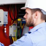 A professional inspecting a fire alarm system